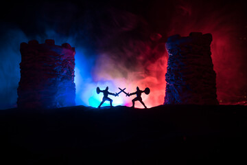 Obraz premium Medieval battle scene. Silhouettes of figures as separate objects, fight between warriors at night. Creative artwork decoration. Foggy background.