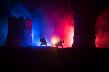 Medieval battle scene. Silhouettes of figures as separate objects, fight between warriors at night. Creative artwork decoration. Foggy background.