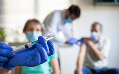 medical team giving coronavirus vaccine to seniors