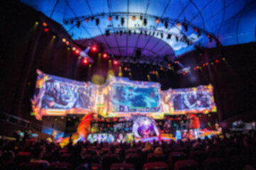 Blurred background of esports event at big arena with a lot of lights and screens. - 410002579