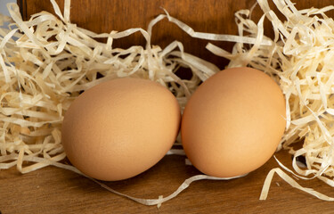  brown egg on a wooden table on a background of paper shavings. High quality photo