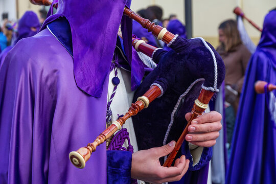 Brother in a procession of Holy Week in Spain playing the bagpipe