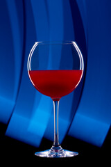 Rounded cocktail glass with a red alcoholic drink on a black background with a light pattern. Light blue drawing.