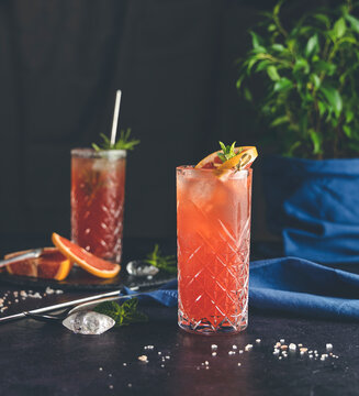 Pink Grapefruit Mezcal Paloma Cocktail In Highball Glass With Water Drops On Table In Real Home. New Life Concept Of Quarantine, Shallow Depth Of The Field, Dark Background.