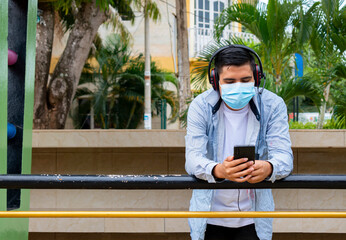 Fototapeta premium young man outdoors looking at his phone: stock photo