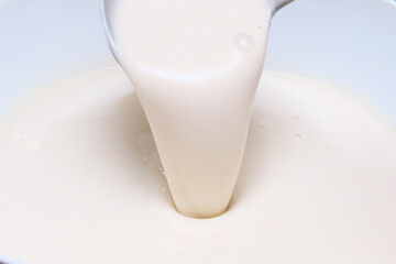 Dough for making pancakes. Batter for pancakes is poured from a large spoon