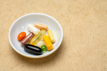 vitamins and supplements - pills, capsules and tablets in a small bowl, healthcare, self care and...