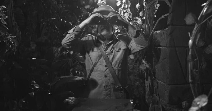 Explorer with binoculars in the jungle