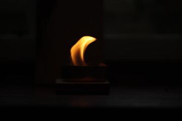 duży  płomień  świeczki  w  ciemnym  pomieszczeniu - 410009517