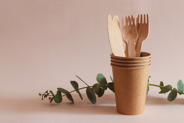 Eco-friendly disposable craft kitchenware. Knives, forks, and paper cups close-up. The concept of zero waste and recycling