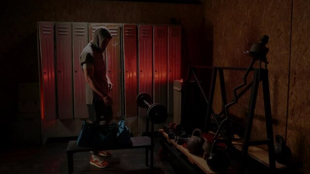 Man get ready for boxing training in the locker room. Red neon light