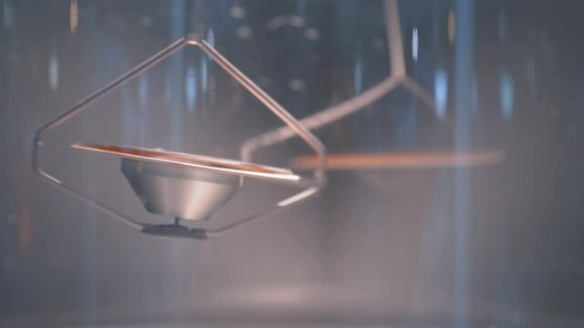 Slow motion: hanging metal gyroscope spinning top pendulum - interactive exposition at science exhibition museum - close up. Physics, experiment, education, laboratory equipment concept