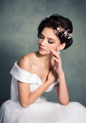 Beautiful bride with fashion hairstyle. Gorgeous young woman in a white dress with jewelry in her hair