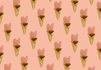 Creative pattern made with golden ice cream cones with heart shadow on the pink pastel background