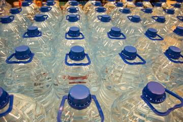 transparent plastic bottles with blue lids with drinking water stand glad