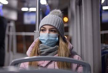 lonely girl in a face mask rides a tram at night in Pandemic time, Poland