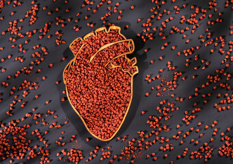 Achiote seeds in heart-shaped bowl - Bixa Orellana