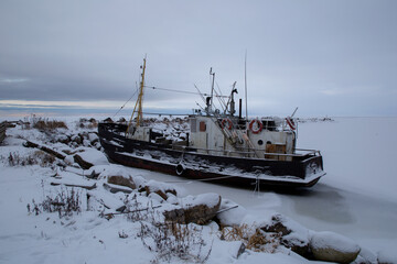 View of the fishing ships on the snow-covered shore of Lake Ladoga