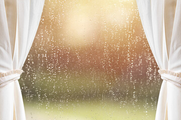 Cream curtains on window glass with raindrops after summer rain. Can be used for display or montage...