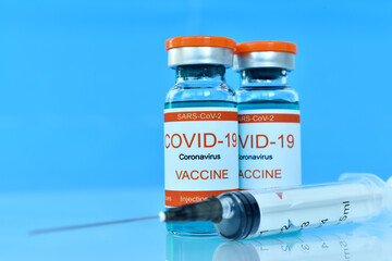 Some ampoules with covid-19 vaccine and syringe injection