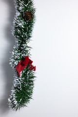 Green decorative Christmas wreath with added decorations and imitation snow on a white background