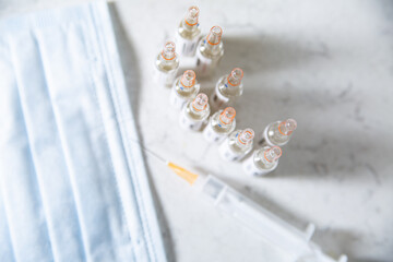 Vaccine bottles, vials, top view, with blurred background.