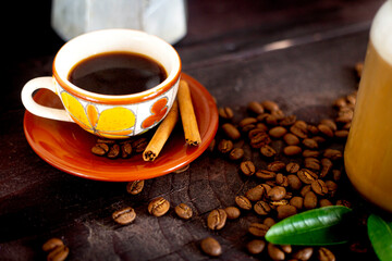 Cup of coffee with coffee beans on a wood table, close up photo