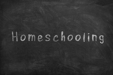 Fototapeta premium Homeschooling. Word Homeschooling written on an old blackboard.