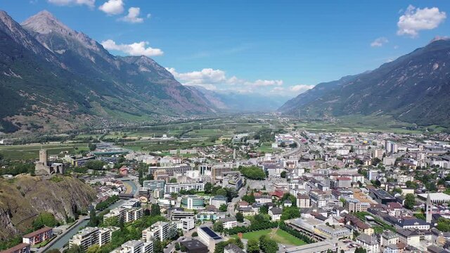 View from drone of houses of commune Martigny and river Drance in mountain valley, Switzerland