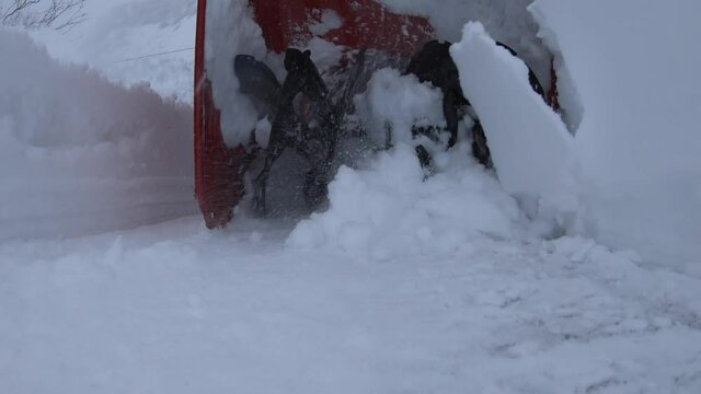 Snowblower blades gathering snow during snow storm