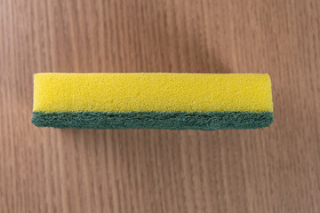 Kitchen sponge on the wooden background