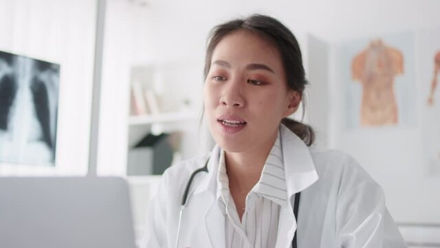 Asian female doctor using laptop computer online video call remote talking to patient, prescribe medicine. Tele medical, telehealth, hospital clinic health care service, or internet technology concept