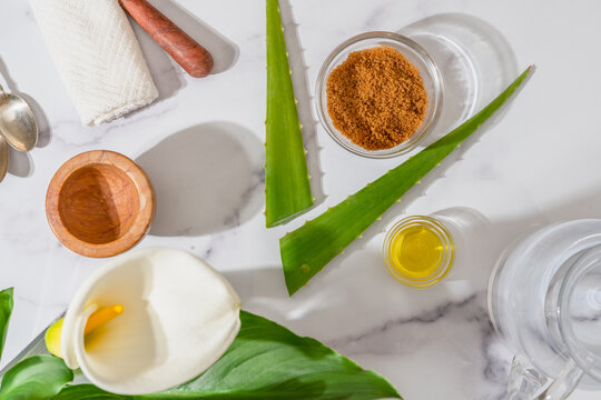 Aloe Vera, Brown Sugar, Olive Oil Close Up On Marble Background. Ingredients For Face And Body Scrub. Skin Care, Organic Ingredients, Cosmetology Concept