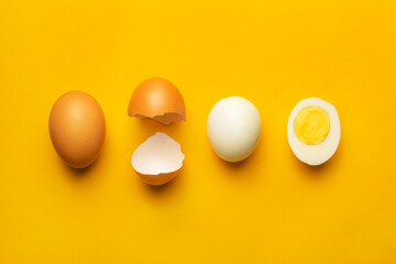 Fresh farm brown chicken boiled egg creative layout and composition on yellow background. Minimalistic healthy food concept. Top view, flat lay