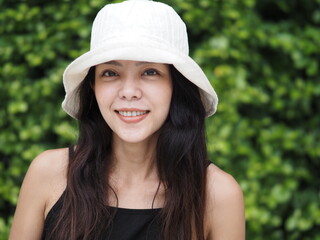 portrait of young asian woman in black dress and white hat