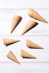 Ice cream cones in hard light on a white wooden background