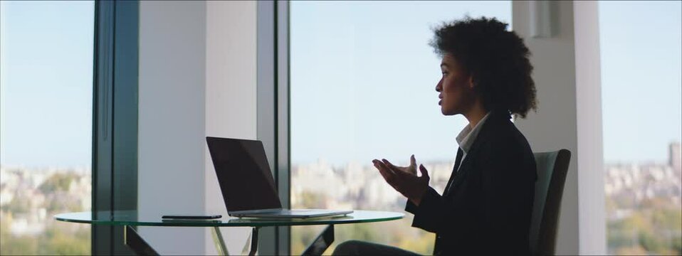 Adult Woman having a conference video call in an office.