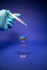 Development of coronavirus vaccine COVID-19. medical syringe with injection needle in blue medical...
