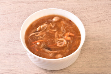 Assorted seafood with scallops soup in white bowl