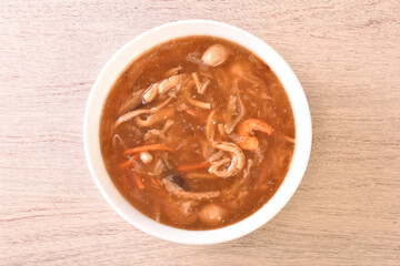 Assorted seafood with scallops soup in white bowl