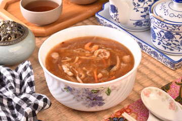 Assorted seafood with scallops soup in white bowl