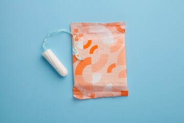 menstruation products, woman intimate hygiene, sanitary pad and tampon on blue, flat layout, top view