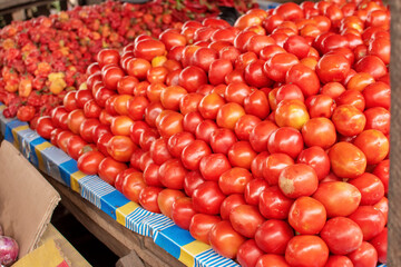 Neatly  arranged pile of tomatoes with scotch bonnets pepper