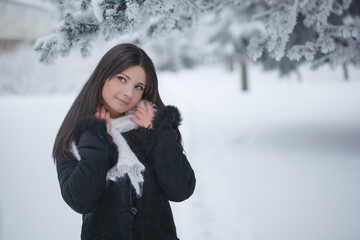 Beautiful girl  on the street in winter.  Woman outdoors against the backdrop of a magical winter landscape.