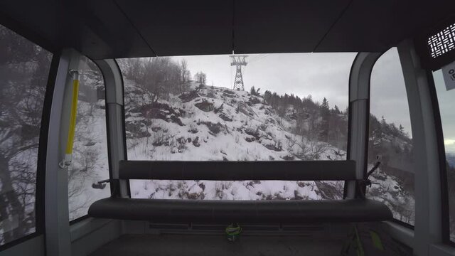 Voss Gondola descending hillside snowy mountain view from inside - Norway