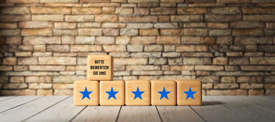 wooden cubes with German message for PLEASE GIVE US YOUR RATING in front of a brick wall