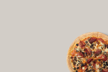 Delicious pizza and ingredients of sausage, bacon and mozzarella on a grey background. Top view of delicious pizza.