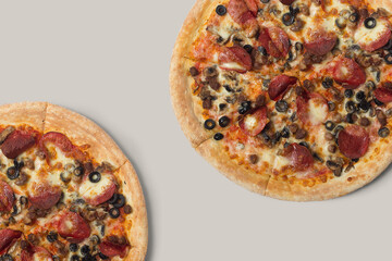 The pizzas are delicious and the ingredients are sausage, bacon and mozzarella on a brown background. can be made of backgrounds, flyers and other forms of advertising,