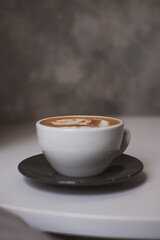 Flat white coffee, flower latte art on white table, hipster coffee shop concept. Minimalist background, copy space