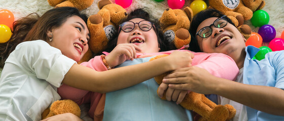 down syndrome teenage girl happy lying on floortogether with family